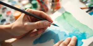 A person painting a calm, flowing watercolor scene.